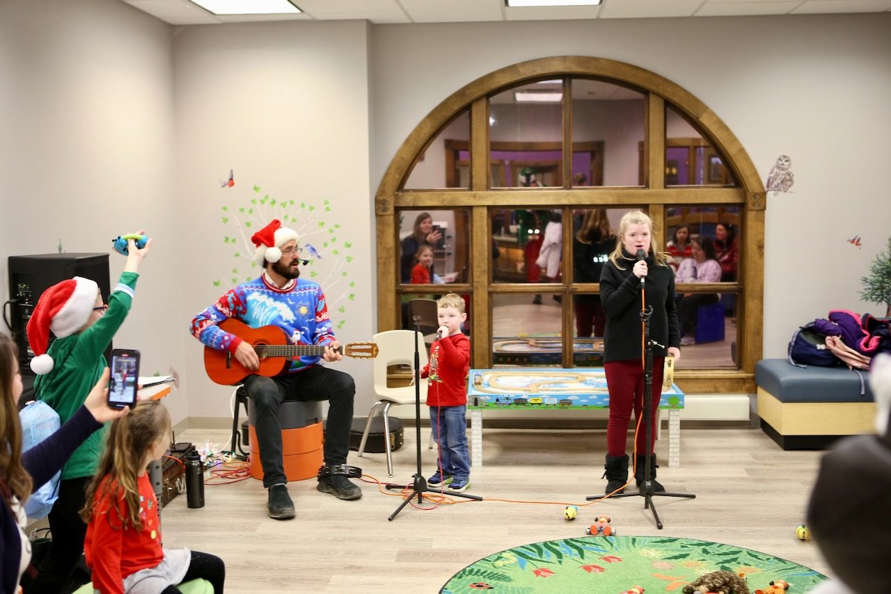 Children singing carols with a guitarist at VIP Christmas