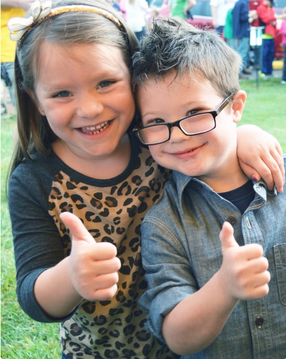 Two children giving thumbs up